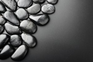Galets noirs brillants sur fond gris foncé